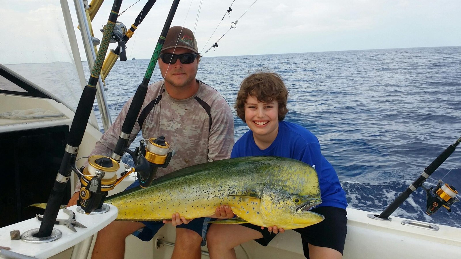 Adult and child holding a mahi mahi aboard Key Largo Fishing Adventures