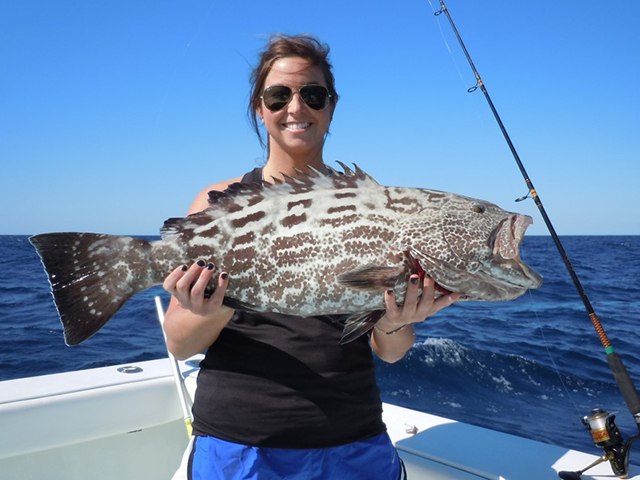 Angler displaying a grouper with Southpaw Fishing