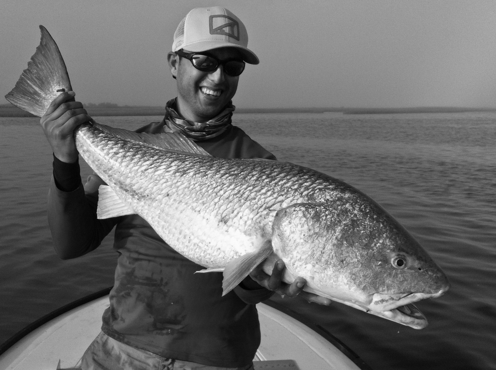 Angler displaying a redfish with Casting Tales