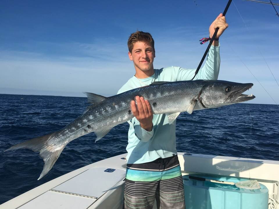Angler displaying a wahoo aboard Shake N Bait Charters
