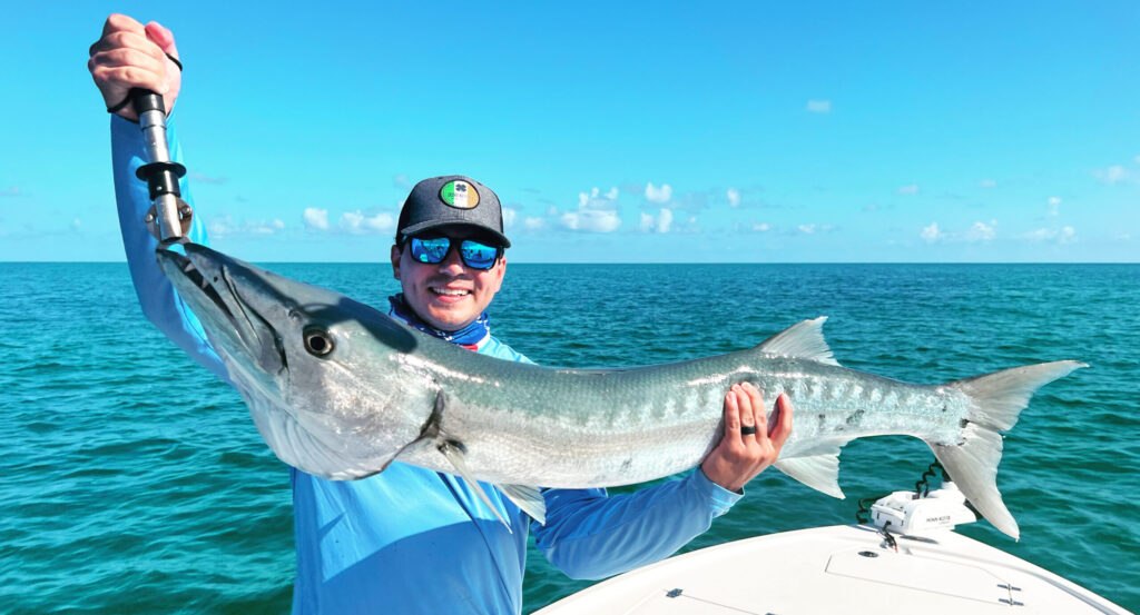 Angler holding a barracuda with All Water Charters