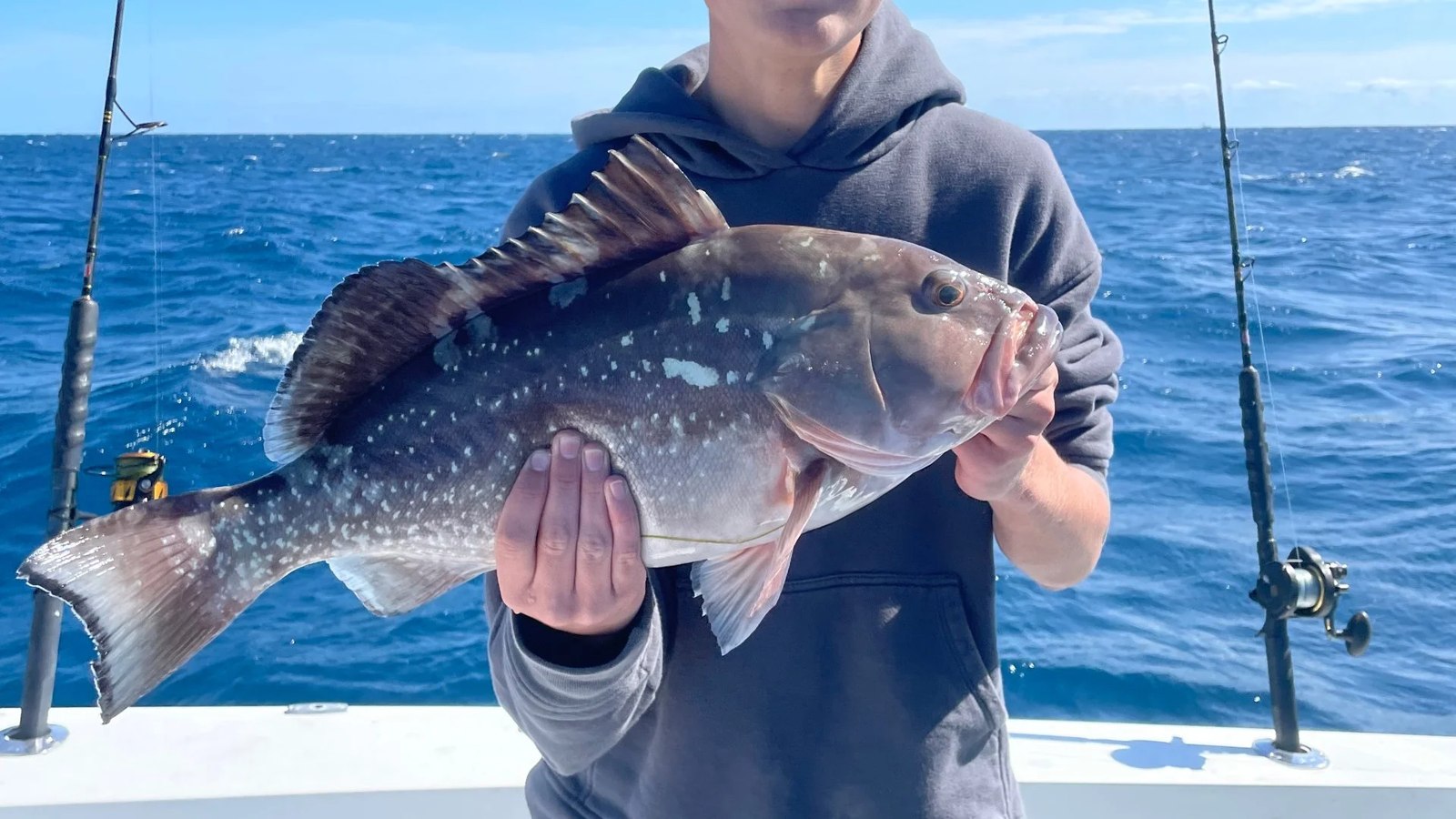 Angler holding a grouper aboard Marathon Fishing Kings