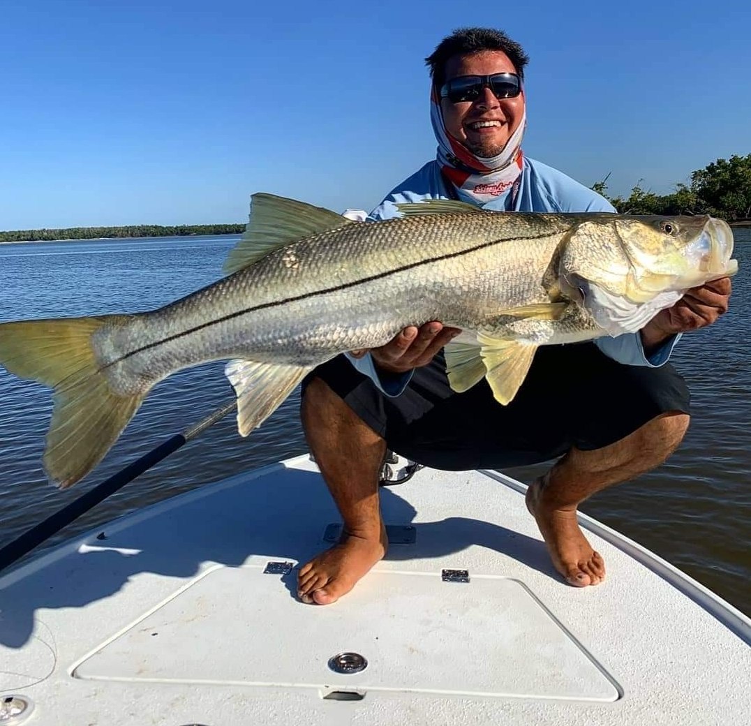 Angler holding a large snook with Slightly Tighter Fishing