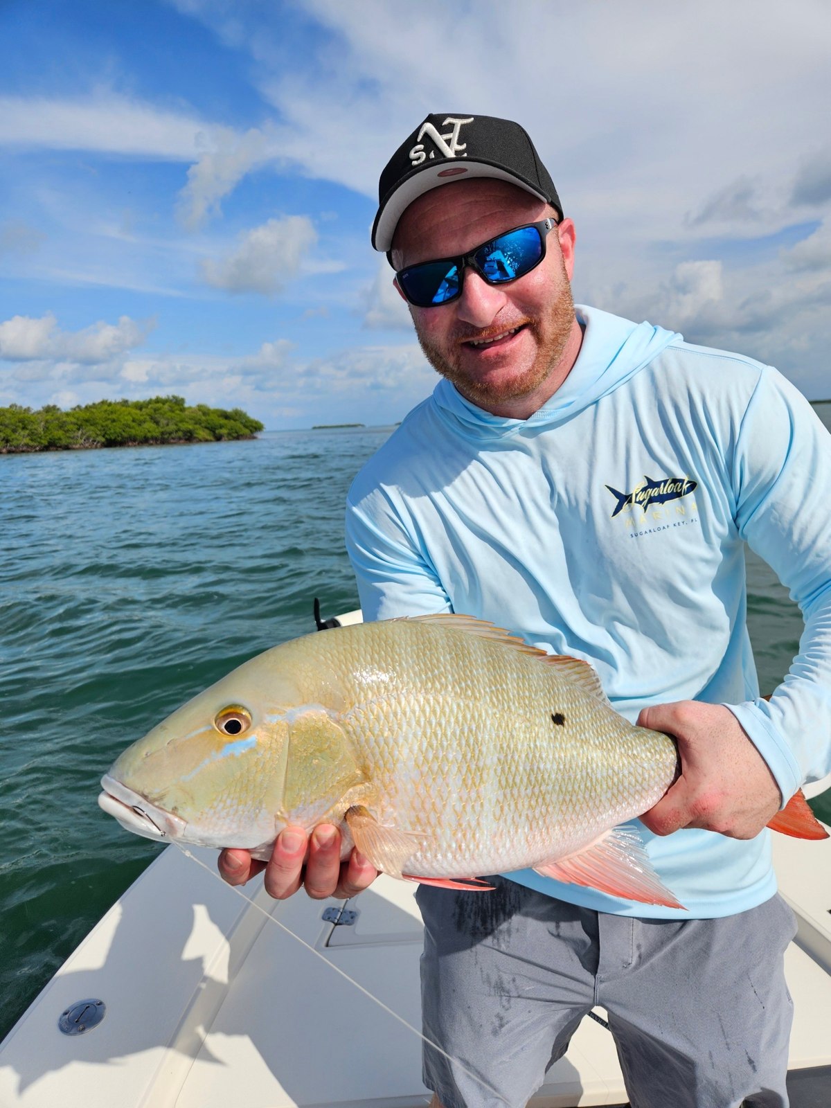 Angler holding a permit with Captain Tim Carlile