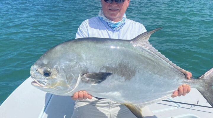 Angler holding a permit with Kingfisher Backcountry Charters
