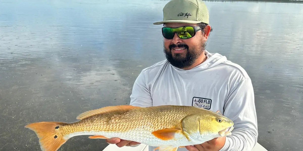 Angler holding a redfish with SO FLO Charters