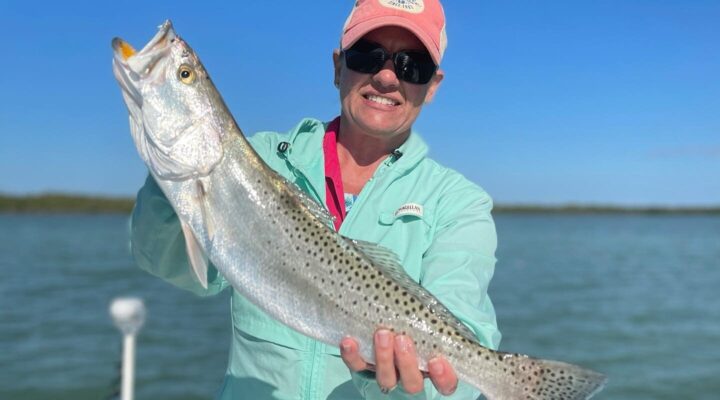 Angler holding a snook aboard an Ankle Deep Fishing Adventures boat