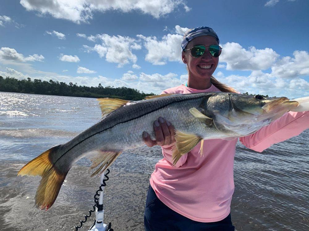 Angler holding a snook aboard Hold Tight Charters