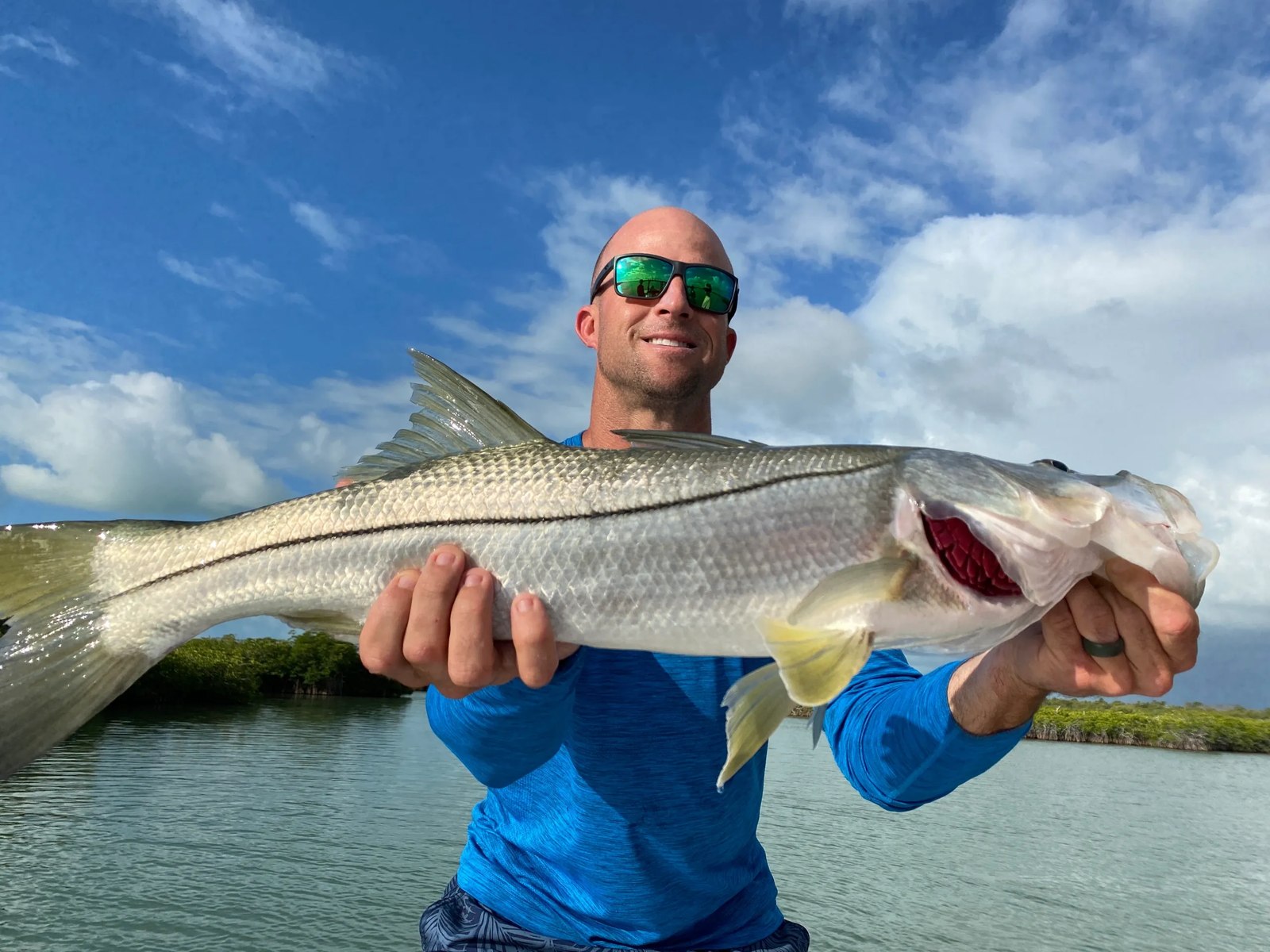 Angler holding a snook aboard Off Course Charters