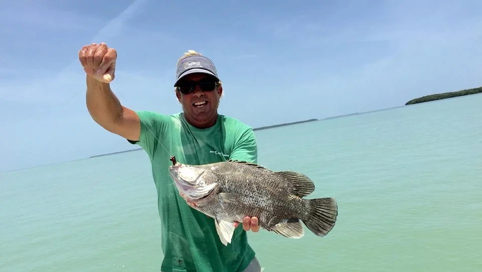 Angler holding a tripletail on a Captain John Johansen fishing trip