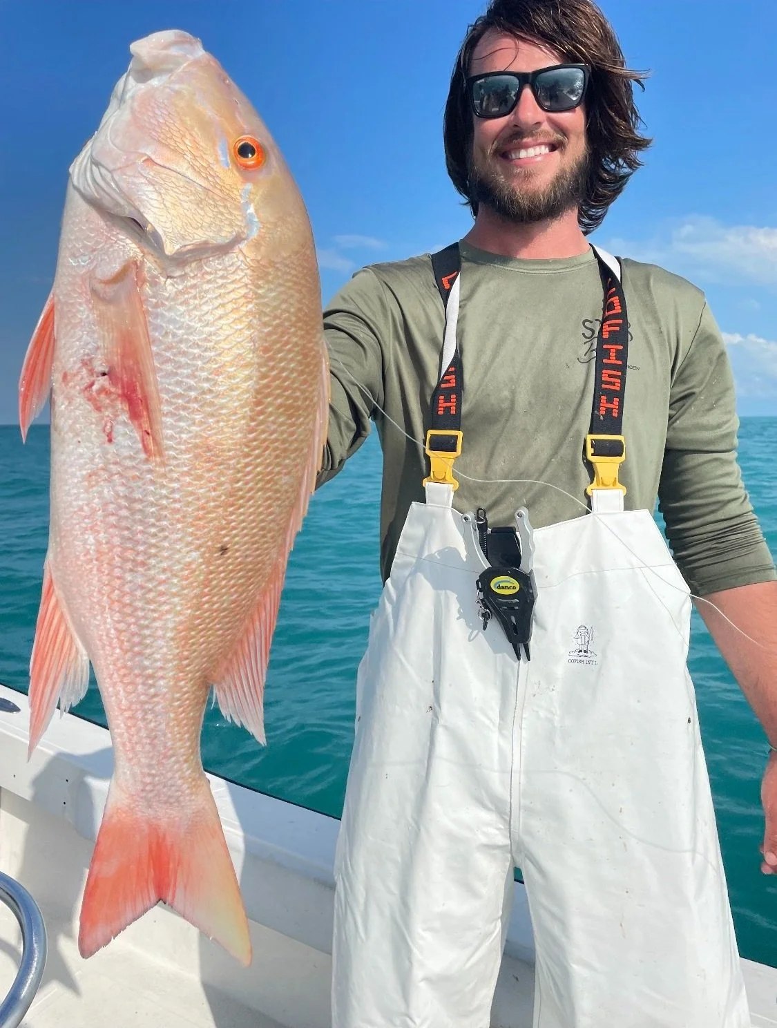 Angler showing a snapper with Screaming Lines Fishing Adventures