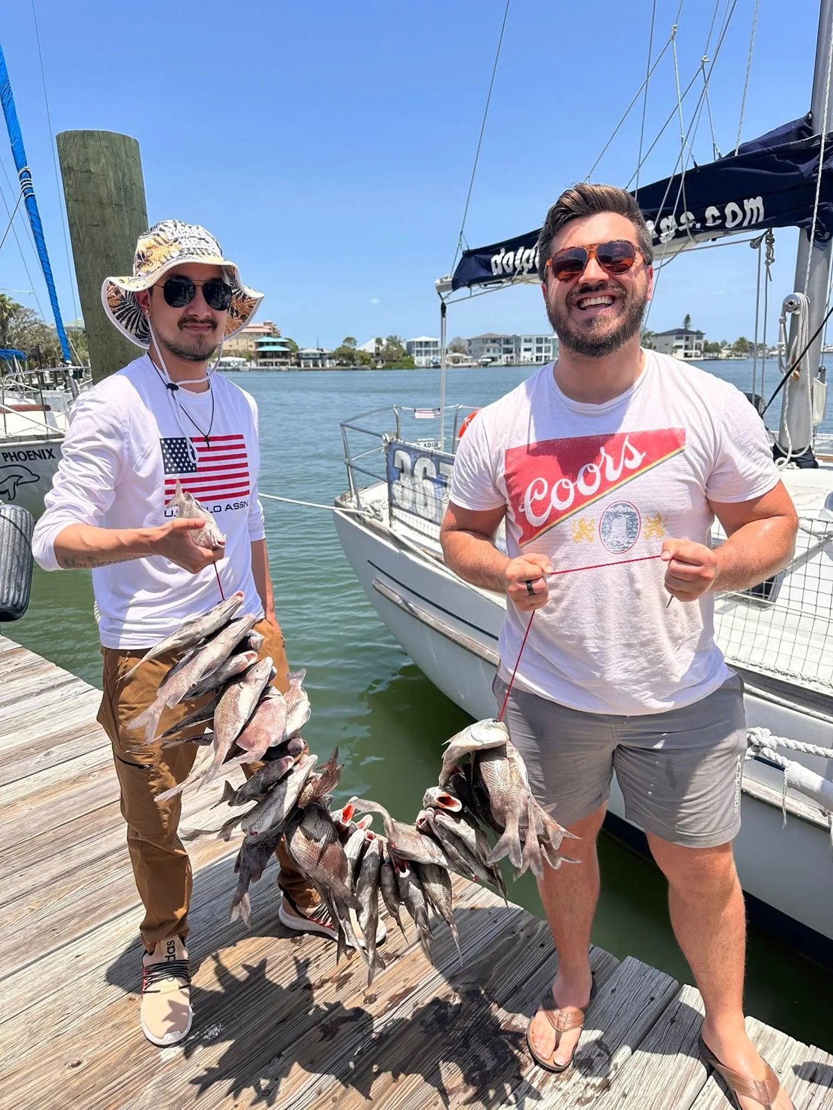 Anglers Dream Fishing anglers holding fish at the dock