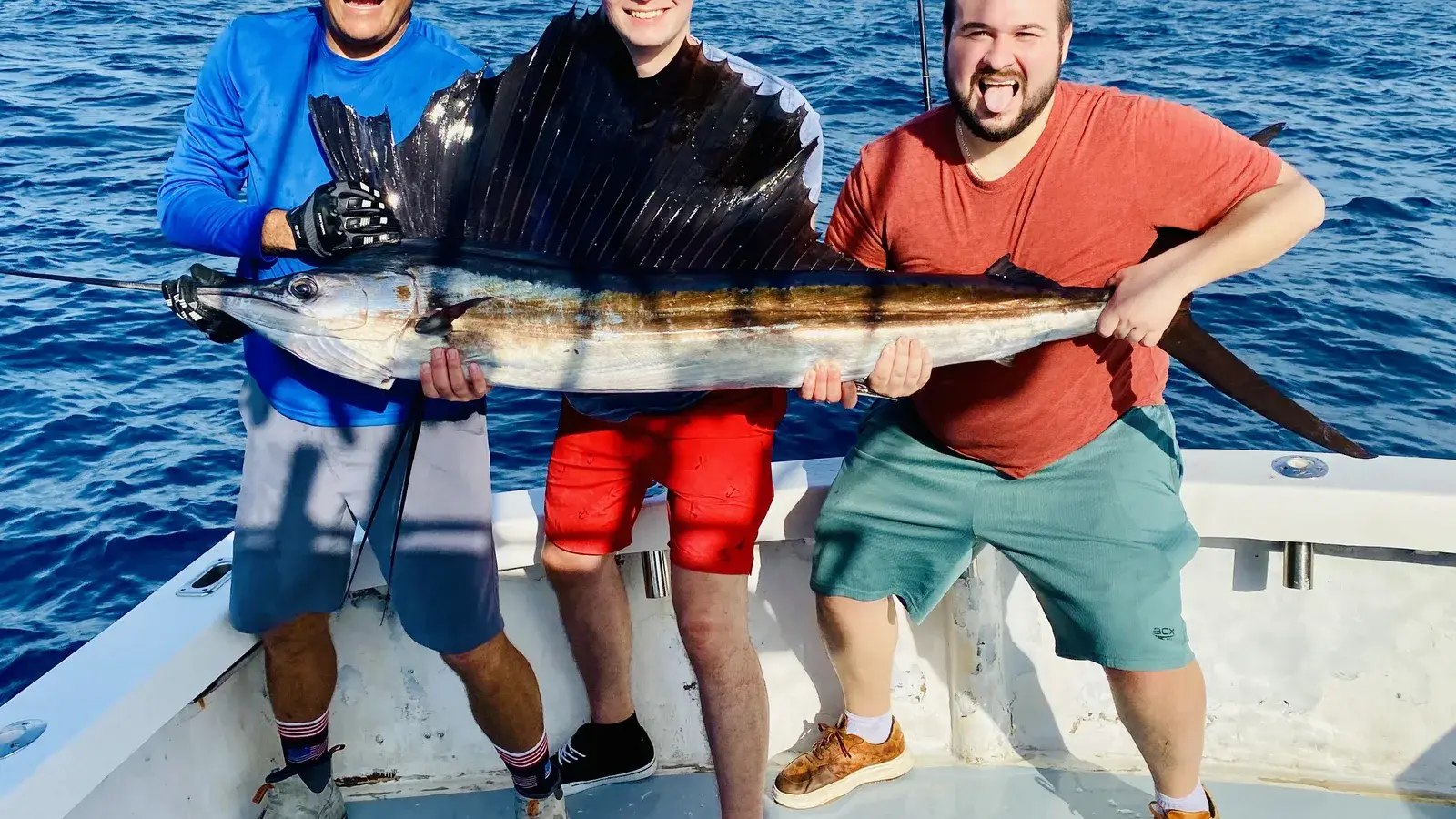 Anglers holding a sailfish aboard a Key Largo Fishing charter