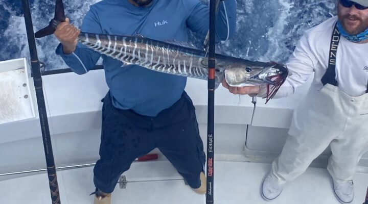 Anglers holding a wahoo aboard Keys Sport Fishing