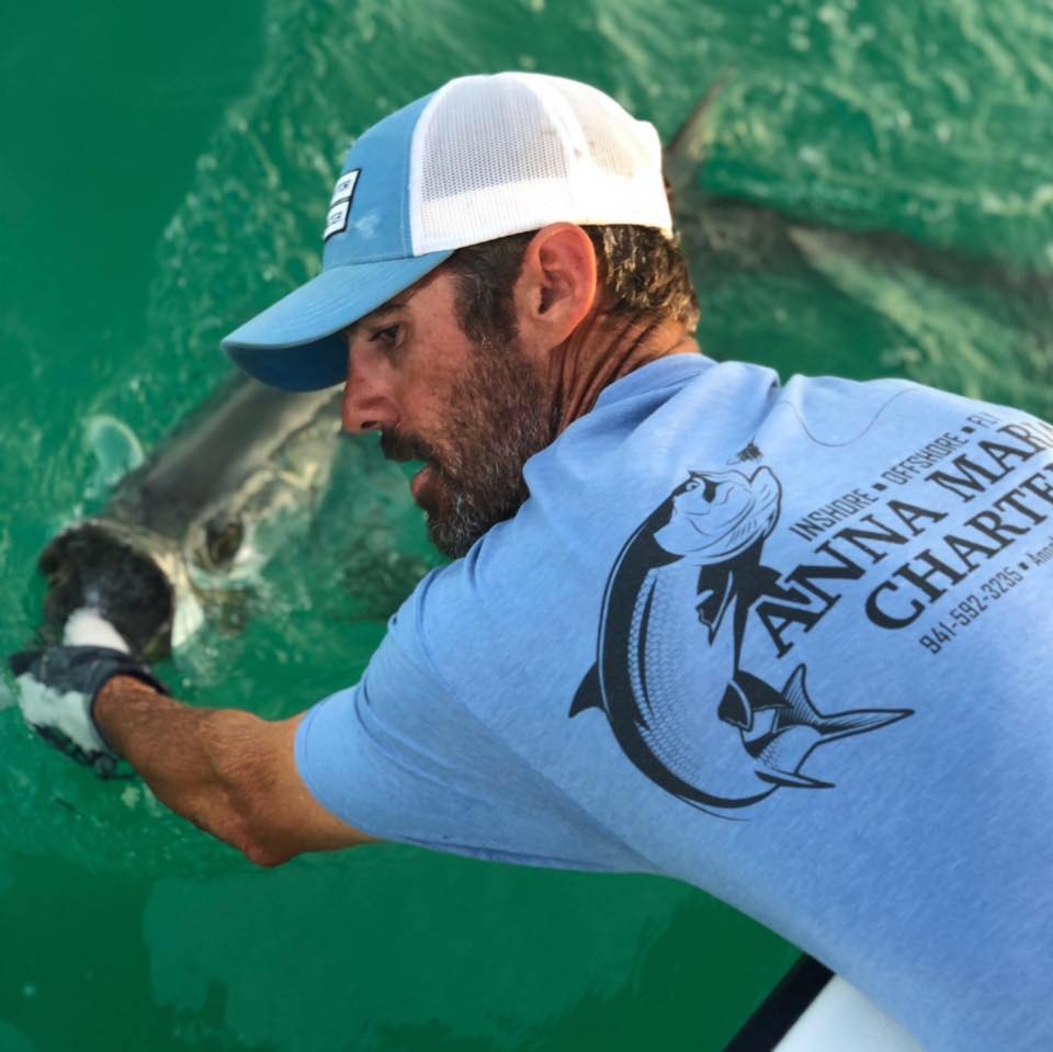 Anna Maria Charters angler handling a fish beside the boat