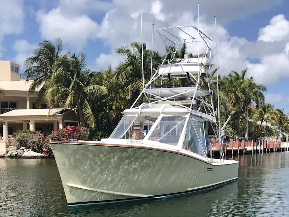 Blue Water Adventures sportfishing boat at a palm lined marina