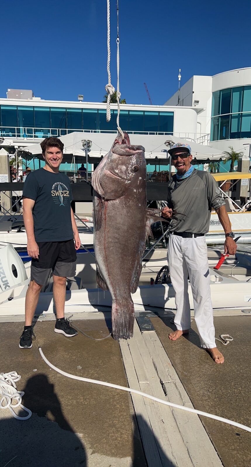 Boat Concierge guests standing with a catch at the dock