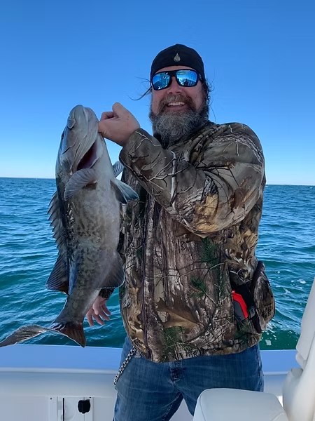 Bust A Knot angler holding two fish on an offshore boat