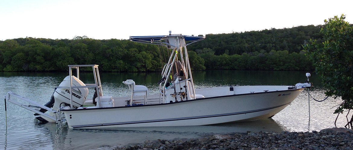 Center console boat moored beside mangroves with Isla Outfitters