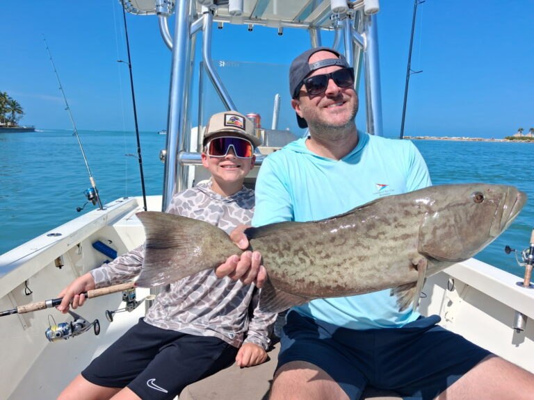 Drag On Charters adult and child holding a grouper