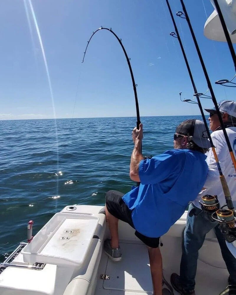 Extreme Fishing Habit guest fighting a fish beside the boat rail