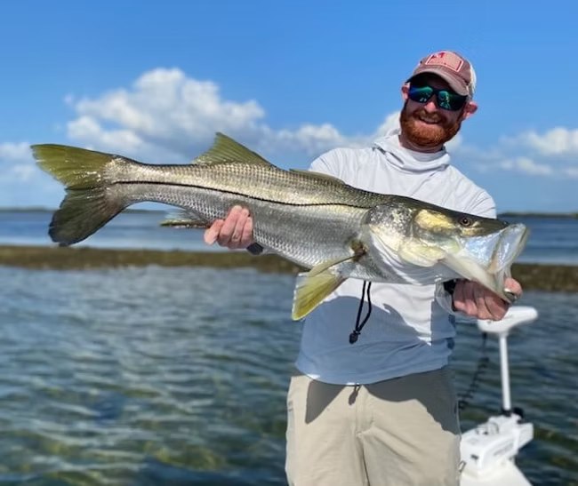 Fish Crystal River angler holding a snook aboard the boat
