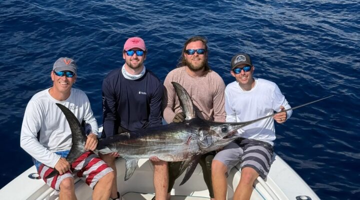 Fishing group holding a sailfish on deck with Reel Escape Sportfishing