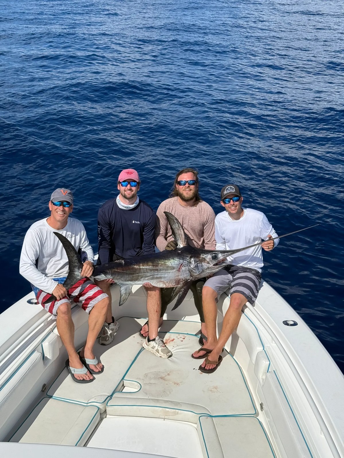Fishing group holding a sailfish on deck with Reel Escape Sportfishing