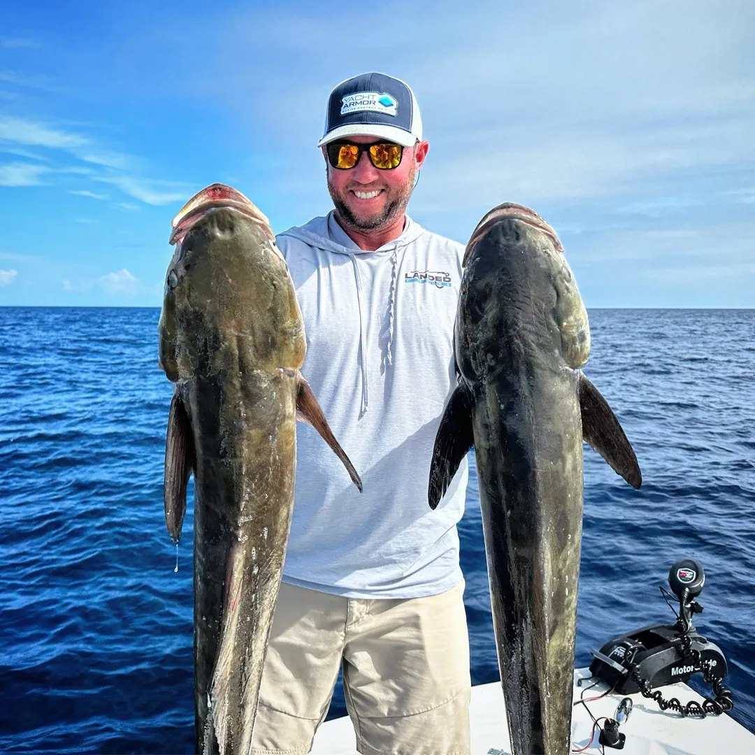 Florida Fishing Co angler holding two grouper