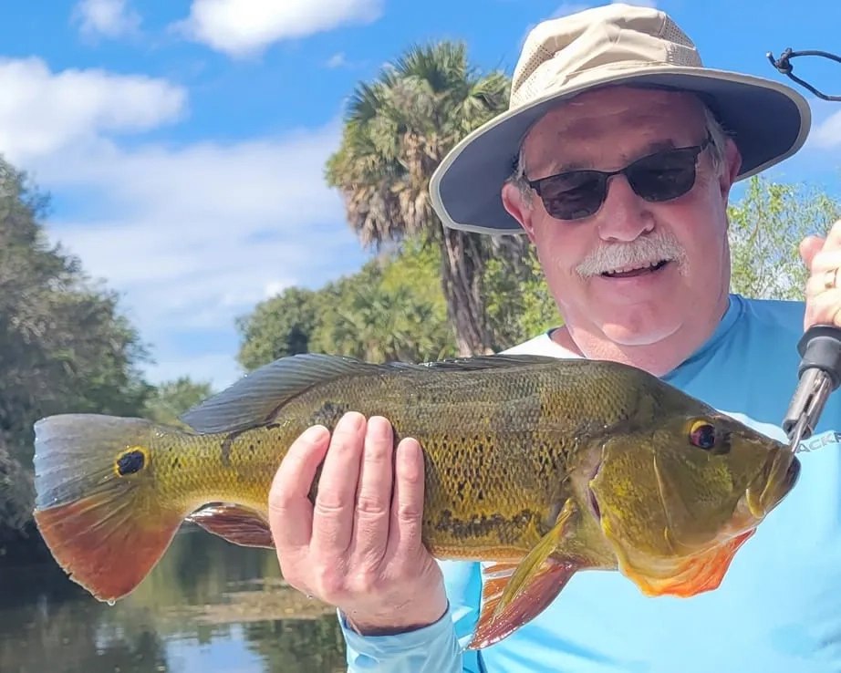 Fred Gowdy Charters angler holding a peacock bass