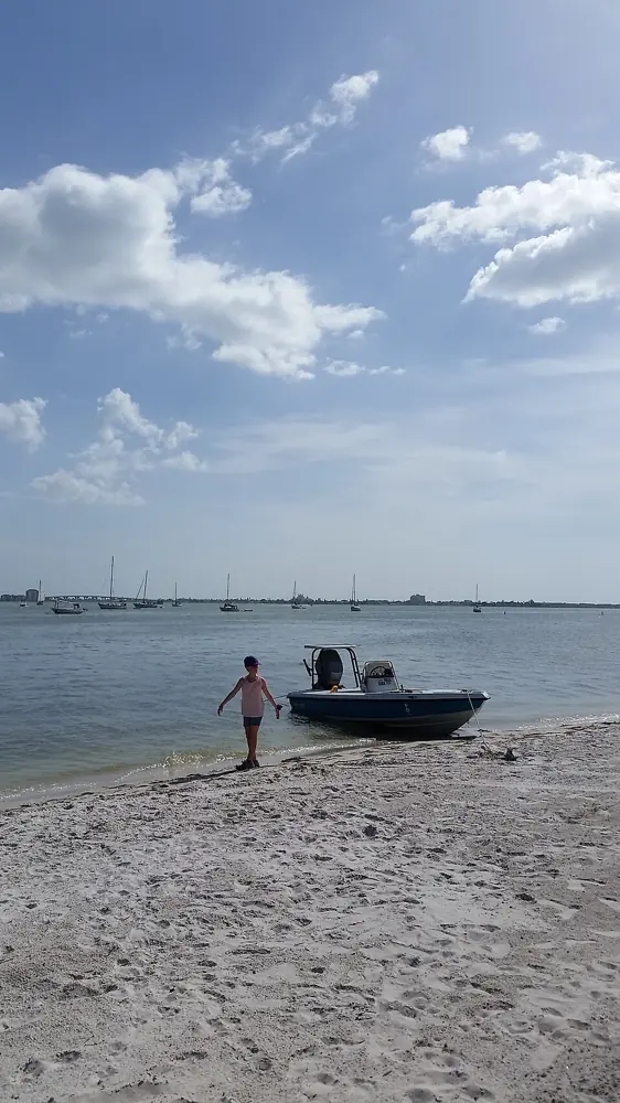 Boat and beachgoer at Gulfport Beach during GeckoFest in 2014