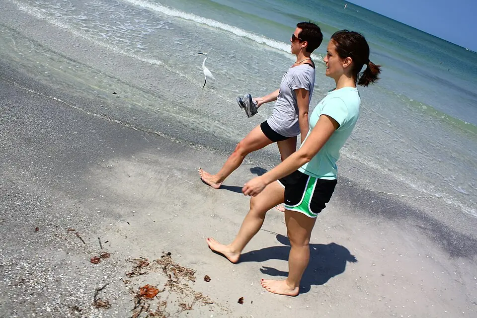 Two young anglers holding fishing rods on the beach at Redington Shores