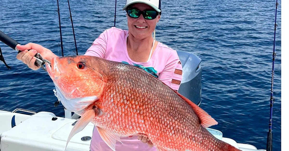 High Octane Fishing guest holding a red snapper beside the boat