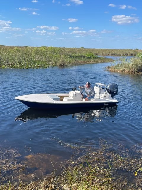 JillyBird Fishing Charters skiff beside mangroves in shallow water