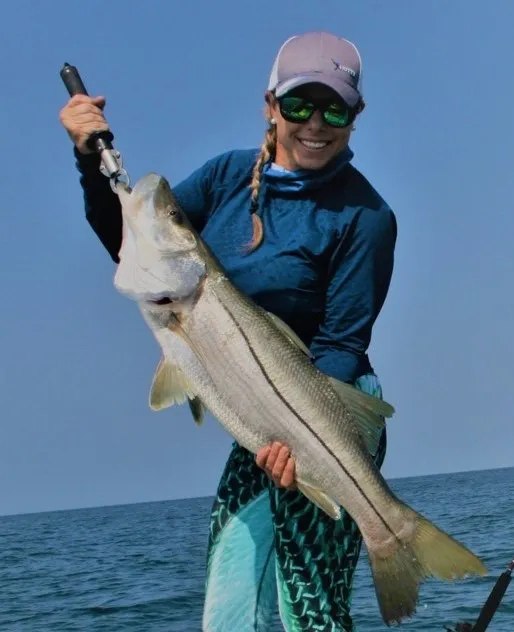 KD Outdoors angler holding a snook beside the boat