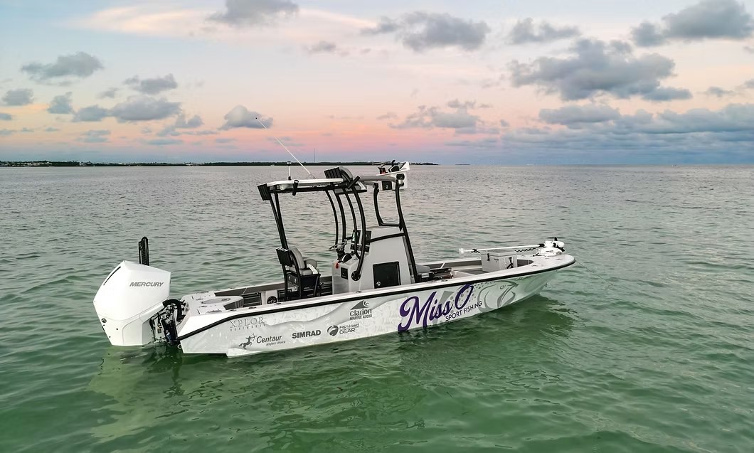 Miss O Sportfishing bay boat floating on calm water at sunset