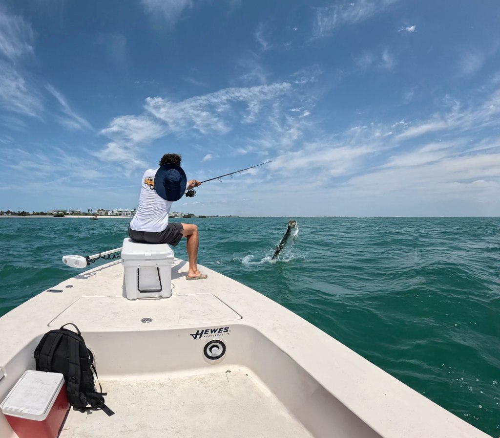 Nauti Dawg angler fighting a jumping tarpon from the bow