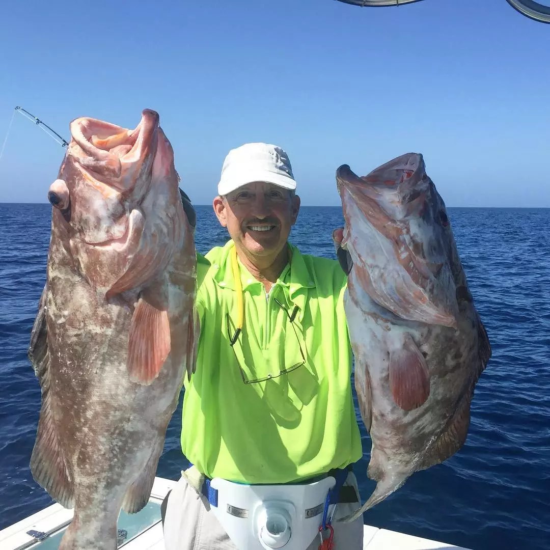 Off Her Radar angler holding two grouper
