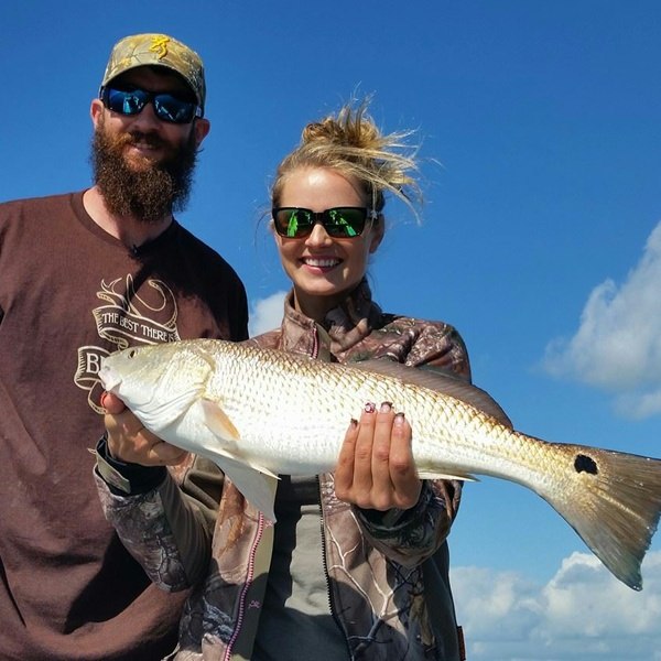 Anglers holding redfish