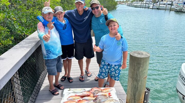 Reel Rebels fishing group beside their catch at the dock