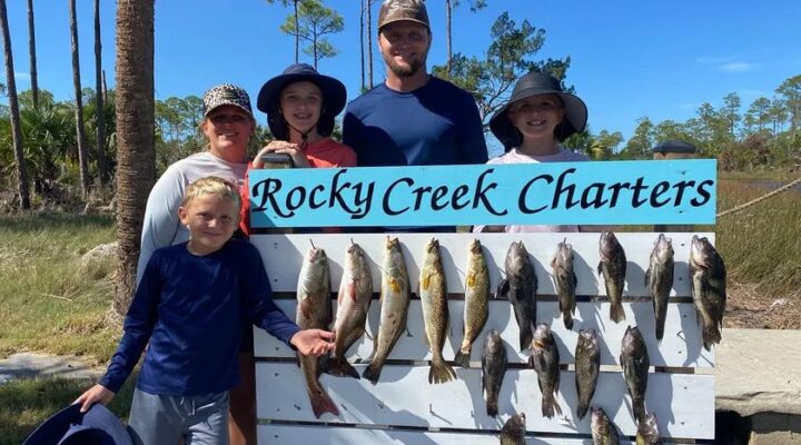 Rocky Creek Charters guests standing behind a rack of their catch