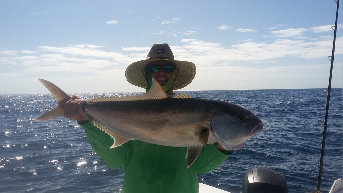 Salty Fishing Charters angler displaying a shark beside the boat