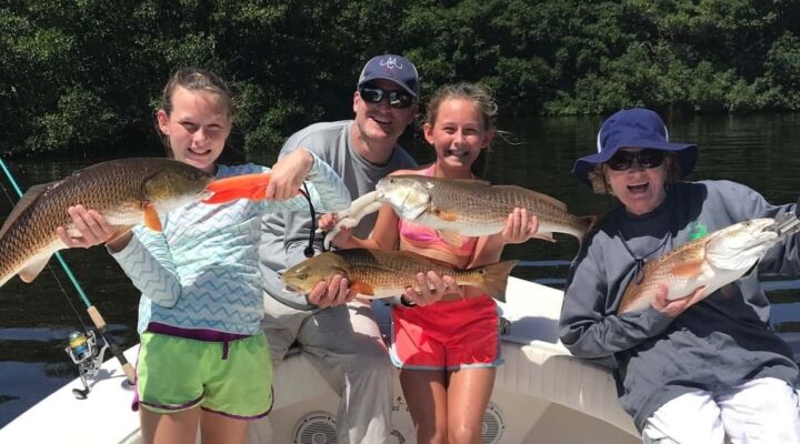 Shallow Point Charters family displaying redfish