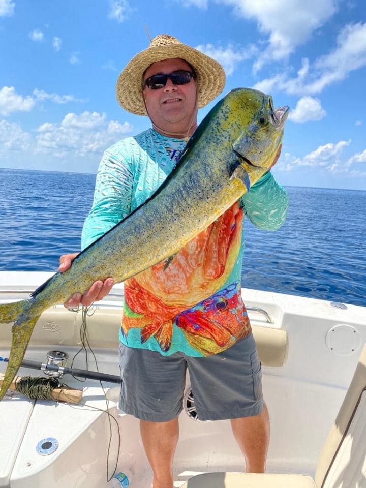 Shell Yeah Charters angler holding a green and yellow mahi-mahi