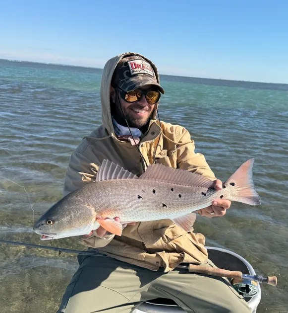 Southern Cut Charters angler holding a spotted redfish