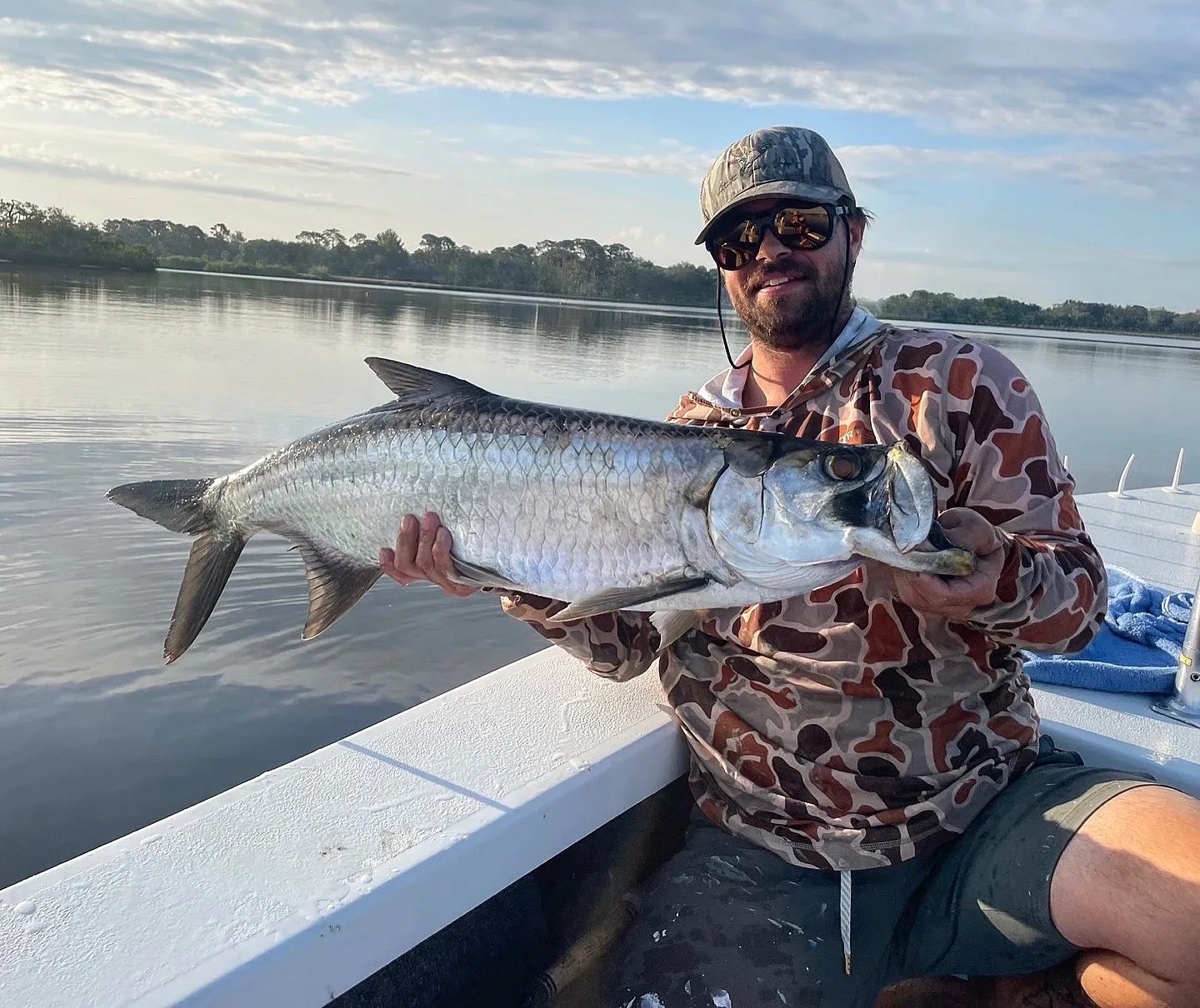 Southern Cut Charters angler holding a tarpon aboard a skiff