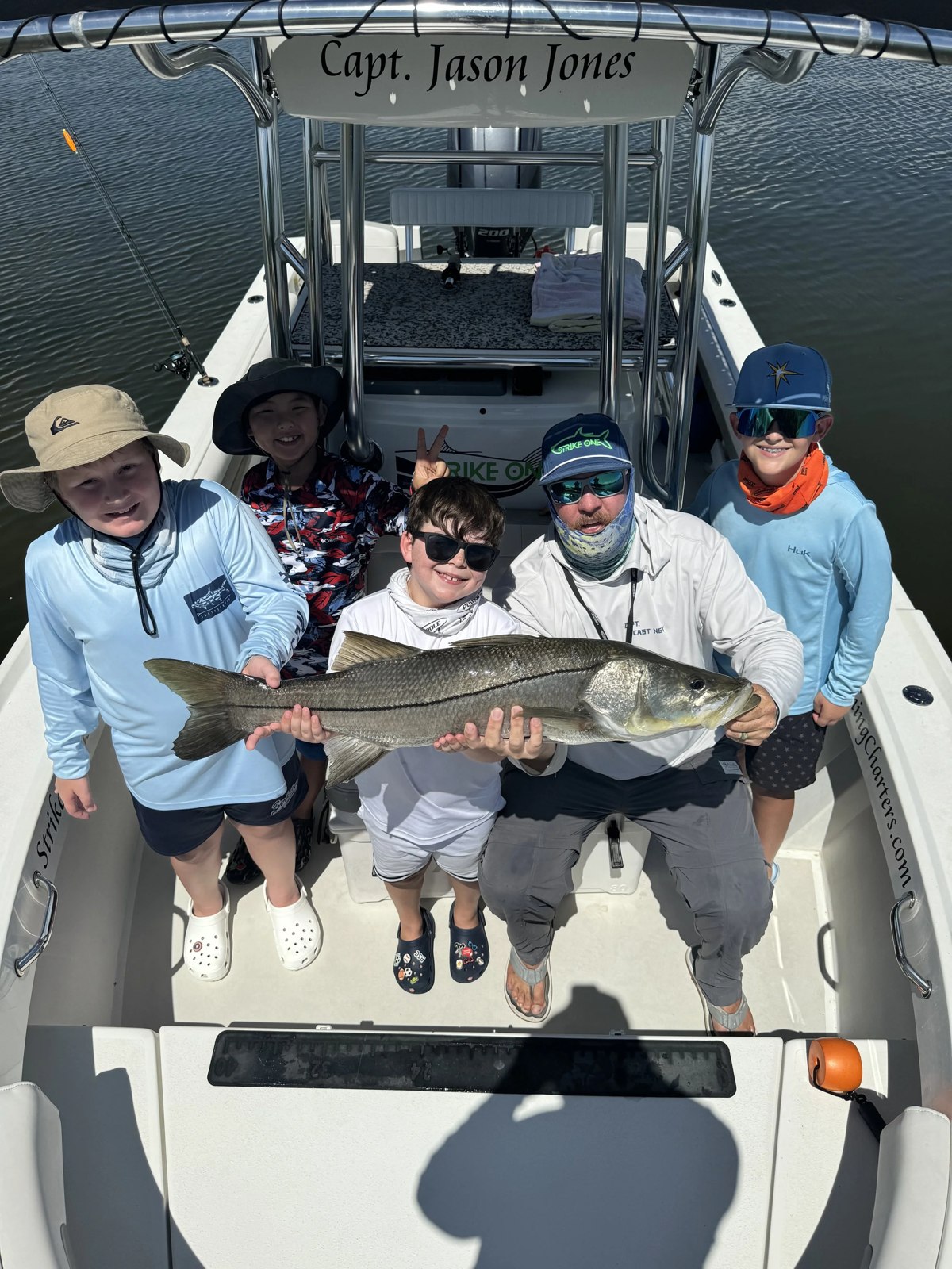 Strike One Fishing Charters group holding a snook on the boat