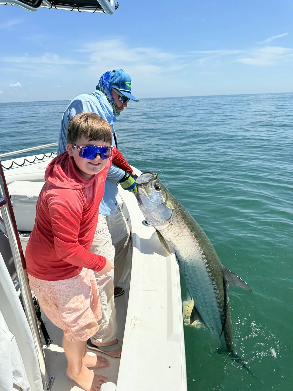 Strike One Fishing Charters young anglers watching a fish beside the boat