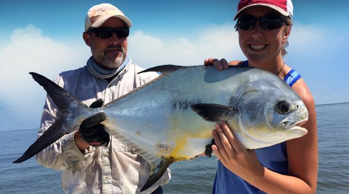 Two anglers displaying a permit on an SFP Fishing Outfitters trip