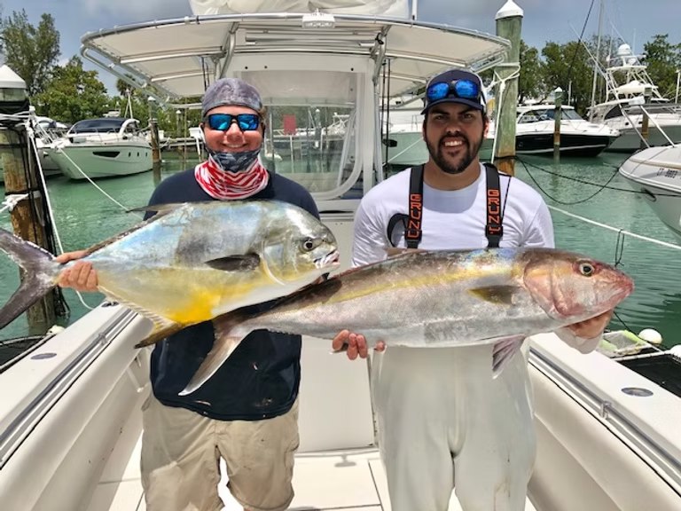 Two anglers displaying their catch at the dock with JillyBird Fishing Charters